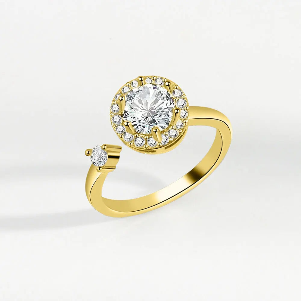 Gold ring with a large diamond and smaller diamonds on a light gray background