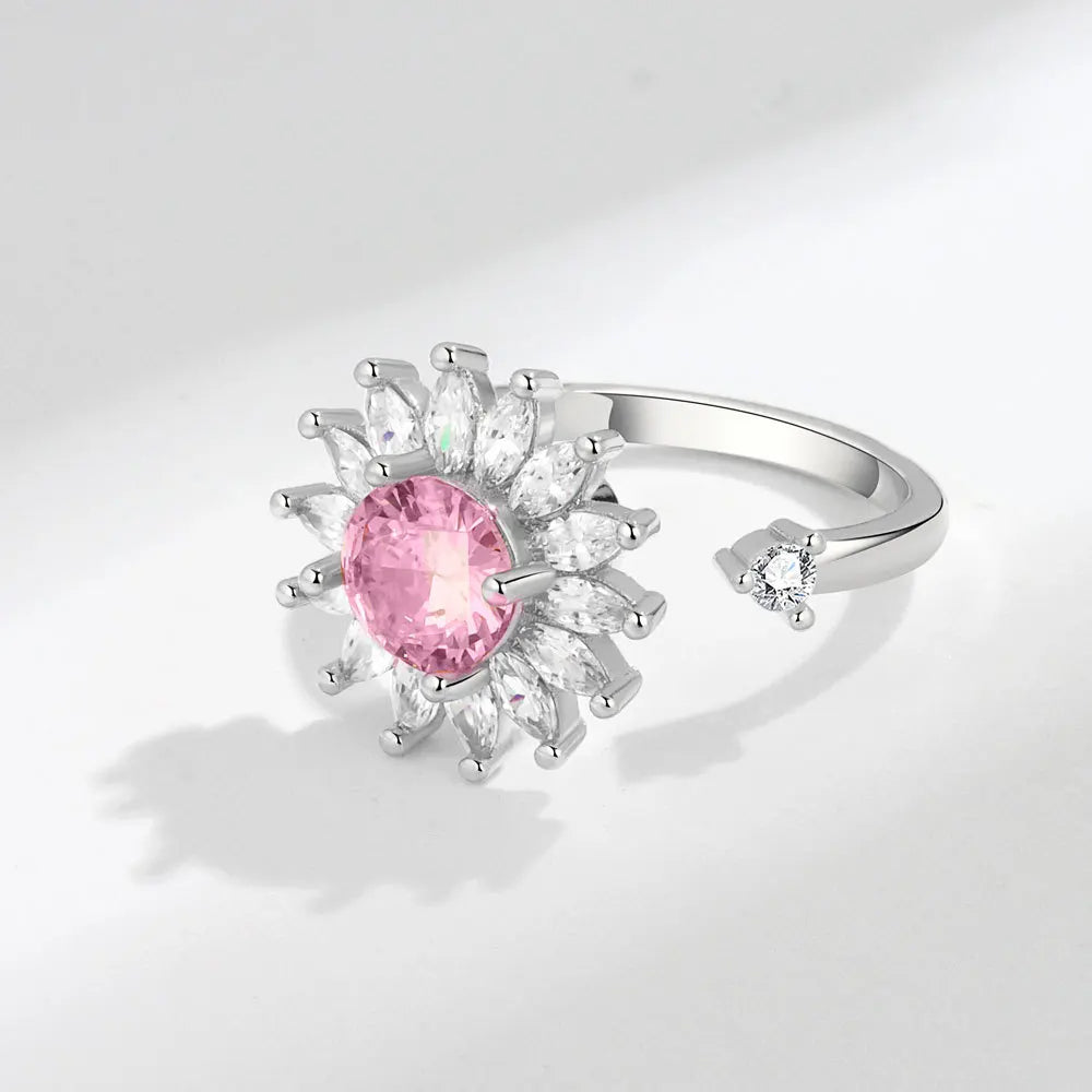 Silver ring with a pink gemstone on a light gray background