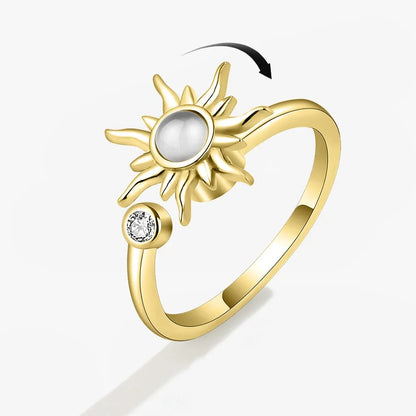 Gold ring with sun design and pearl center on a white background